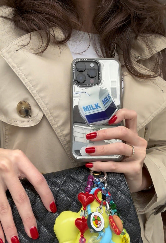 Pop Grippy de "Dairy Me", vista lateral en mano, accesorio para sujetar el celular, agarre seguro para móvil.