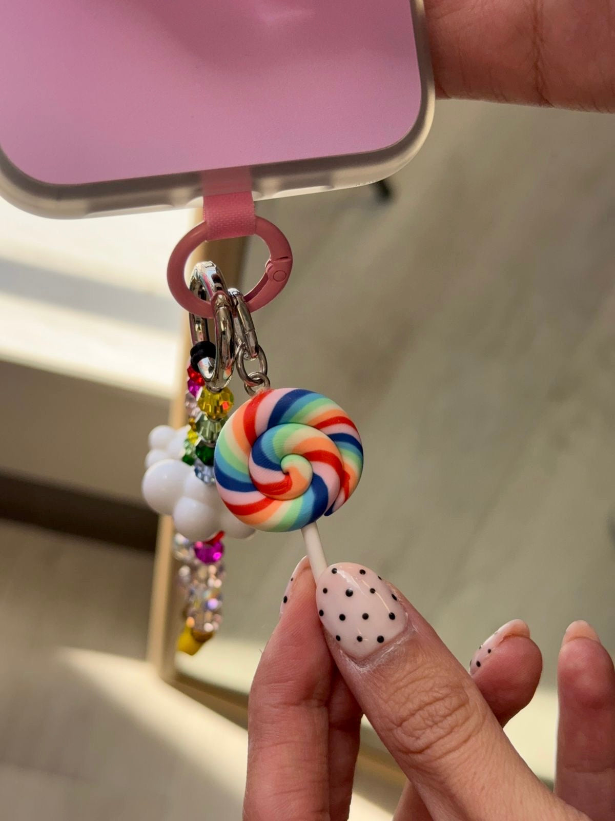 Colgante para celular Blue Rainbow Pop Swirl Charmie de Build a Caze, accesorio en forma de paleta con diseño de espiral multicolor en tonos azul, rosa y verde para decoración de teléfonos móviles.