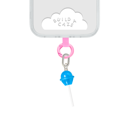 Un charm y accesorio colgante Blueberry Pop Charmie en color azul sujeto a un celular - Build A Caze