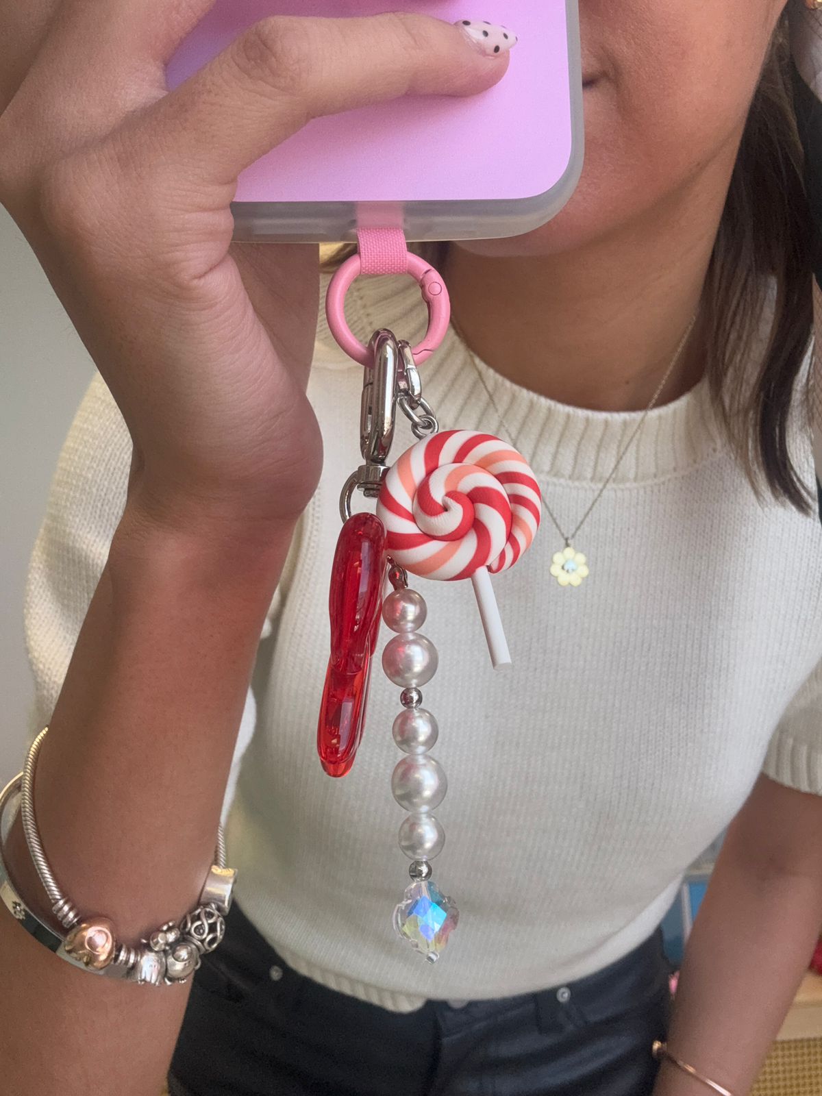 Colgante para celular L'Orange Swirl Charmie de Build a Caze, accesorio en forma de paleta con diseño de espiral en color naranja para decoración y personalización de teléfonos móviles.