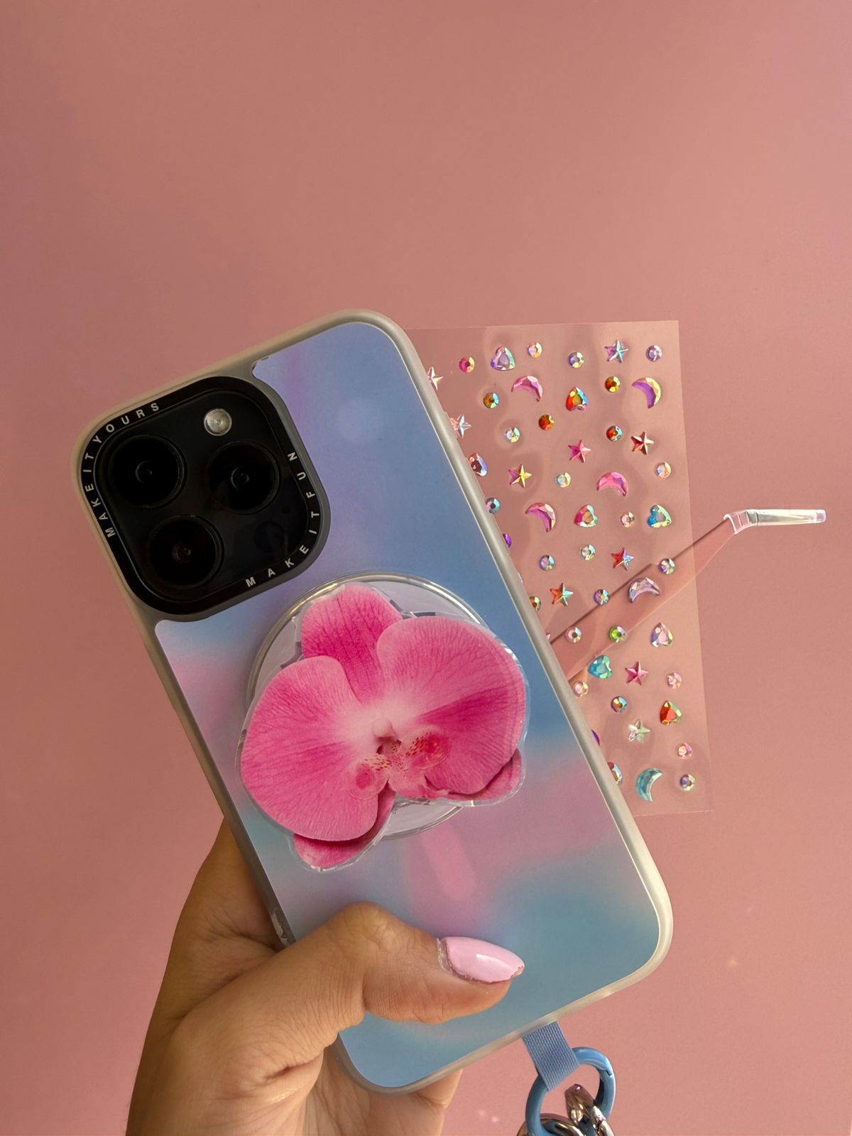 Kit floral y colorido Kit con Pop Grippies de Main Character Sunflower, Oopsy Daisy y Orchid Obsession, y Sticky Gems en plano cenital sobre superficie blanca - Build A Caze