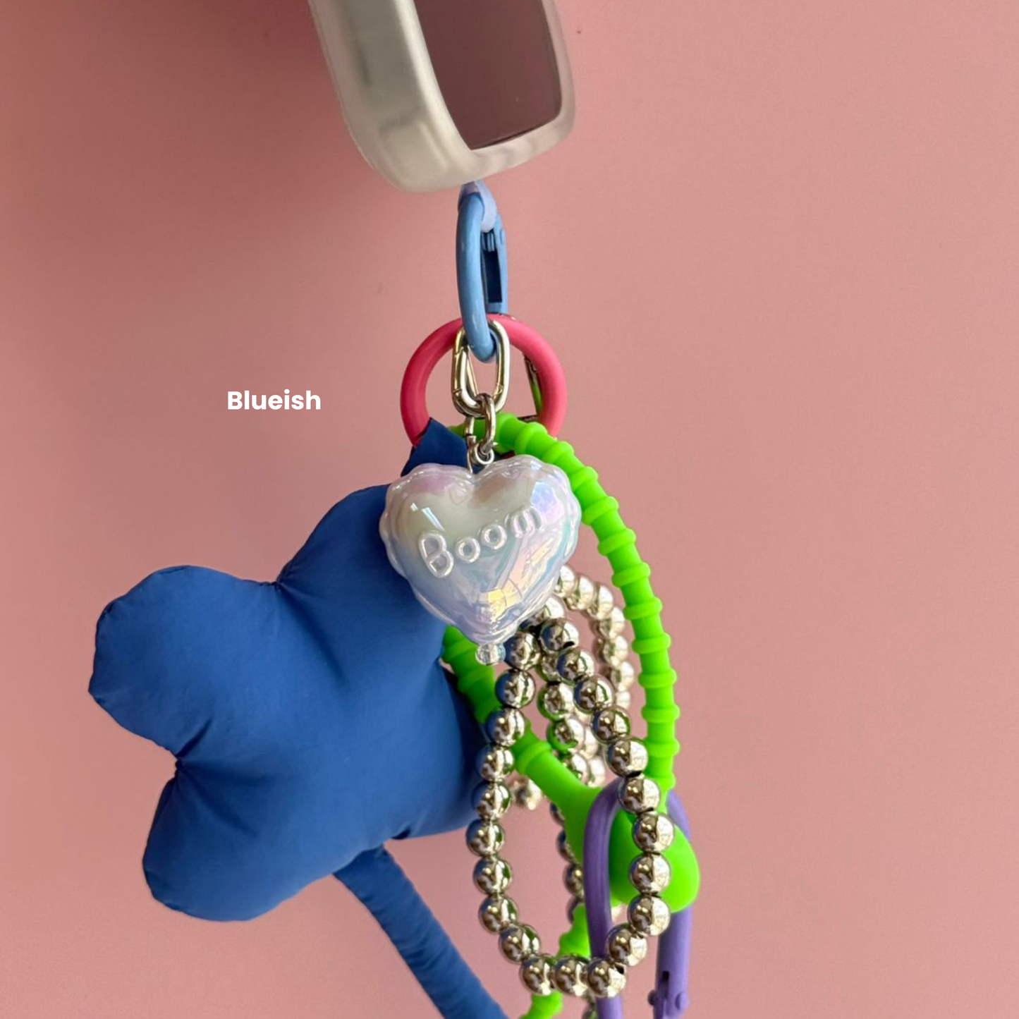 Un charm y accesorio colgante mint color menta sujeto a un celular - Build A Caze.